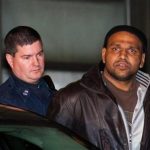 Ray Lazier Lengend, accused of involvement with hurling crude Molotov cocktails at an Islamic cultural center and four other New York-area sites on New Year's Day, is led out of the 103rd precinct in Jamaica, Tuesday, Jan. 3, 2011, in Queens borough of New York. Lengend was taken into custody Tuesday after he was tracked through a car with Virginia license plates that was believed to be at the scene of at least two of the attacks. (AP Photo/John Minchillo)