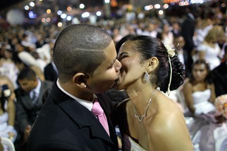 A couple kisses during a mass wedding ceremony