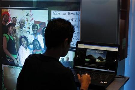 A visitor looks at the online Nelson Mandela Digital Archive on a computer screen during its launch at the Nelson Mandela foundation in Johannesburg March 27, 2012. Thousands of letters, photographs and documents relating to former South African President Mandela went online on Tuesday in a project to increase access to archives on the life of the global human rights icon. Items including letters Mandela wrote to his family and smuggled out of prison, his Methodist church membership card from about 80 years ago and hand-written diaries have been digitised and laid out in a site designed to look like museum exhibits at archive.nelsonmandela.org. REUTERS/Siphiwe Sibeko