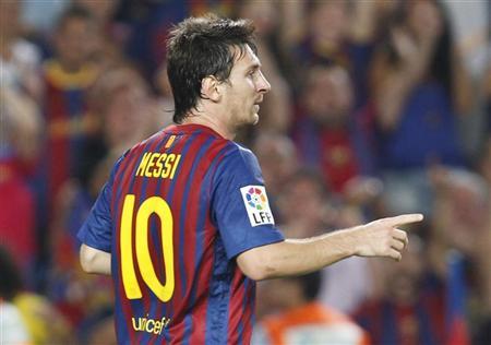Barcelona's Lionel Messi celebrates his third goal against Osasuna during their Spanish first division soccer match at Nou Camp stadium