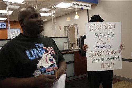 Empowering and Strengthening Ohio's People member Tony McNary talks with other protesters in a Chase Bank branch in Cleveland