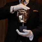 A British Academy of Film and Television Arts (BAFTA) award mask is displayed by an employee during a media viewing at the Savoy Hotel in London February 8, 2012. REUTERS/Stefan Wermuth