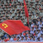 A party flag waves as soldiers and policemen attend the opening ceremony of a revolutionary song singing concert to celebrate the upcoming 90th anniversary of the founding of the Communist Party of China (CPC) on July 1, at Chongqing Olympic Sports Centre in Chongqing municipality June 29, 2011. REUTERS/Jason Lee