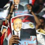 Supporters of Egypt's former vice president Omar Suleiman hold up signs with an image of him as they gather in Abassiya Square in Cairo April 6, 2012. Suleiman said on Friday he would run for president if supporters complete his paperwork within a day, putting one of ousted leader Hosni Mubarak's closest allies back in the race days after he ruled himself out. REUTERS/Mohamed Abd El Ghany