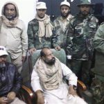 A mobile phone picture taken by one of his guards shows Saif al-Islam Gaddafi with his captors, November 19, 2011. REUTERS/Handout