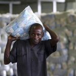 A worker carries packets of sugar at a sugar factory in Kenya, April 29, 2010. REUTERS/Noor Khamis