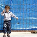 A Syrian refugee boy gestures as he stands in front of the fence at Yayladagi refugee camp in Hatay province near the Turkish-Syrian border April 17, 2012. REUTERS/Umit Bektas