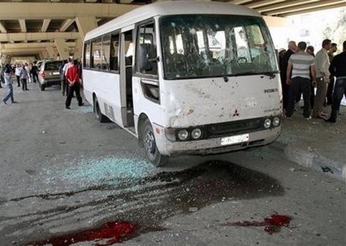 Mideast Syria Syrian investigators, right, gather next to a damaged police bus that was attacked by an explosion in the Midan
neighborhood of Damascus, Syria, on Friday April 27, 2012. A suicide bomber blew himself up across the street from a mosque
in the Syrian capital Friday, killing several people and wounding 20, state TV said. Thousands of Syrians protested elsewhere
to denounce persistent violence by President Bashar Assad's regime. (AP Photo/Bassem Tellawi)