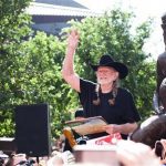 Singer Willie Nelson waves beside a statue of himself during its unveiling in downtown Austin, Texas April 20, 2012. REUTERS/Julia Robinson
