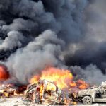 Smoke rises from burning cars at the site of the twin blasts in Damascus on May 10