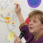 German Chancellor Angela Merkel points at a world map during a visit of the German Spanish Europa School Friedensburg on a European project day in Berlin, May 14, 2012. REUTERS/Thomas Peter