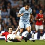 Manchester United's Park Ji-Sung (on ground) challenges Manchester City's Carlos Tevez (C) during their English Premier League soccer match at the Etihad Stadium in Manchester, northern England, April 30, 2012. REUTERS/Darren Staples