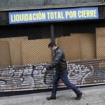 A man walks past a closed store with a sign reading "Total clearance closure" in downtown Madrid April 19, 2012. REUTERS/Andrea Comas