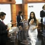 Former Playboy model and presidential debate assistant Julia Orayen (white) hands out cards to the four candidates during a televised debate at the Federal Electoral Institute in this handout still image taken from video, in Mexico City, May 7, 2012. REUTERS/Instituto Federal Electoral/Handout/ via Reuters TV