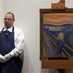 An employee stands next to "The Scream" painted by Edvard Munch at a Sotheby's auction in New York May 2, 2012. REUTERS/Andrew Burton