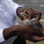 A man counts his cash in South Africa, June 15, 2010. REUTERS/Michael Buholzer