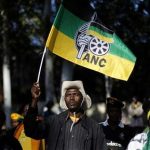 An African National Congress (ANC) supporter holds the party's flag during a march to the Goodman Gallery in Johannesburg May 29, 2012, where a portrait exposing South African President Jacob Zuma's genitals were first displayed. REUTERS/Siphiwe Sibeko