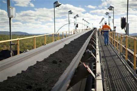 A man walks next to handling and processing equipment at Macarthur Coal's Coppabella mine, about 760km (472 miles) northwest of Brisbane, in this undated handout photograph made available July 12, 2011. REUTERS/Macarthur Coal/Handout