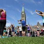 People take part in a free weekly yoga class on the front lawn of Parliament Hill in Ottawa August 17, 2011. REUTERS/Chris Wattie