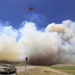 A helicopter flies down US highway 89 as smoke from the Wood Hollow fire fills the sky north of Fairview, Utah, June 26, 2012. More than 500 structures have been threatened by the Wood Hollow fire, forcing up to 1,500 people from homes. REUTERS/George Frey