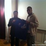 An undated handout photo shows Zhou Jun (L), director of Shanghai Shenhua Football Club, and soccer player Didier Drogba holding up a souvenir jersey of Shanghai Shenhua FC during a meeting in France. Drogba ended weeks of speculation about his future by joining big-spending Chinese Super League strugglers Shanghai Shenhua on June 20, 2012. No financial details of the two-and-a-half-year contract were revealed by former Chelsea player Drogba or the club but widespread media reports said the Ivory Coast striker would receive in the region of $300,000 a week. REUTERS/Shanghai Shenhua Football Club/Handout
