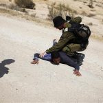 An Israeli soldier holds down a suspect who tried to circumvent a roadblock set up by a road leading to the site of an attack on the Israel-Egypt border June 18, 2012. REUTERS/Amir Cohen