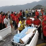 Members of a rescue team carry dead bodies next to the site of a passenger bus crash on a wet road in the southwestern state of Guerrero June 24, 2012. REUTERS/Margarito Perez Retana