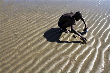 File photo of a man searching for clams during low tide outside of the capital Maputo Ignacio Elias searches for clams during low tide outside of the capital Maputo in this February 1, 2011 file photo. Recent coal and gas discoveries could become a game-changer for the war-scarred economy where more than half of its 23 million people still live in poverty, but there are worrying signs that the mineral wealth is not trickling down. REUTERS/Matthew Tostevin/Files