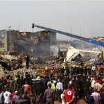 People watch as a crane removes wreckage from the site of a plane crash at Iju-Ishaga neighbourhood, Lagos June 4, 2012. REUTERS/Akintunde Akinleye