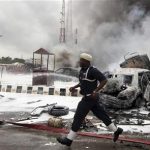 Members of emergency services work at the scene of an explosion at a police station after a suspected suicide bomber was killed and many vehicles were destroyed in Abuja June 16, 2011. REUTERS/Afolabi Sotunde