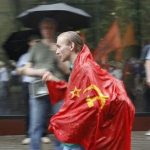 An activist wearing a Soviet flag walks in the rain during an anti-government protest in Moscow June 12, 2012. REUTERS/Maxim Shemetov