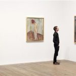 Duncan Holden of the Tate poses with three paintings of Edvard Munch's "Weeping Woman" series at the Tate Modern in London's Southbank, June 26, 2012. REUTERS/Andrew Winning