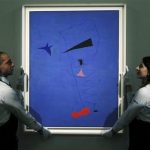Gallery assistants pose with Joan Miro's Peinture (Etoile Blue) which is on display at Sotheby's in central London, June 14, 2012. REUTERS/Olivia Harris