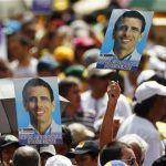 Supporters of opposition candidate Henrique Capriles hold up election portraits while attending a rally before the registration of his presidential bid to the electoral authorities in Caracas June 10, 2012. REUTERS/Jorge Silva