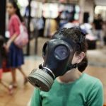 An Israeli boy receives help to fit a gas-mask to his head at a distribution center in a shopping center in Mevaseret Zion on the outskirts of Jerusalem on July 25, 2012.