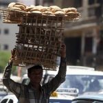 A man carries bread on wooden racks to be sold to customers in Cairo July 2, 2012. REUTERS/Amr Abdallah Dalsh