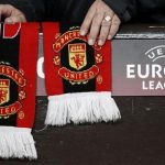 A Manchester United supporter adjusts a club scarf before their Europa League second leg round of 32 soccer match against Ajax at Old Trafford in Manchester, northern England, February 23, 2012. REUTERS/Phil Noble