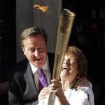 Britain's Prime Minister David Cameron (L) greets Olympic torch bearer Florence Rowe (R) after she received the flame in Downing Street in London July 26, 2012. REUTERS/Cathal McNaughton