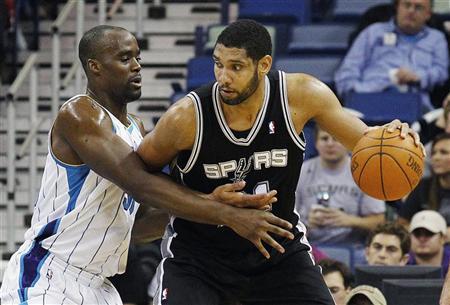 San Antonio Spurs center Tim Duncan (R) works against New Orleans Hornets center Emeka Okafor during the first half of their NBA basketball game in New Orleans, Louisiana January 23, 2012. REUTERS/Bill Haber