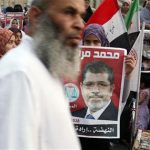A supporter holds a poster of Egypt's President Mohamed Mursi at Tahrir square in Cairo July 10, 2012. REUTERS/Asmaa Waguih