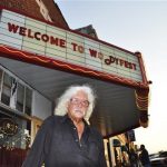 Arlo Guthrie stands outside Okemah's refurbished movie theater that hosts Woodyfest, the annual folk festival that honors his father, Woody Guthrie in Okemah, Oklahoma July 11, 2012. For a man who has been dead since 1967, it has been a good year for folk singer Guthrie, who would have turned 100 on July 14, 2012. New books have been published, more Guthrie songs have been released and in the small Oklahoma town where he was born, nobody wants to burn him in effigy for his politics. Photo taken July 11, 2012. REUTERS/Steve Olafson