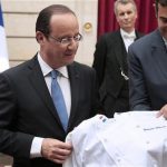 France's President Francois Hollande is presented a chef's jacket with his name during a reception of the "Club des Chefs des Chefs" (Club of Leaders' Chefs) at the Elysee Palace in Paris, July 24, 2012, following the International meeting in France. REUTERS/Jacques Demarthon/Pool