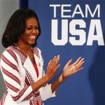 U.S. first lady Michelle Obama claps as she arrives at a Team USA athletes breakfast in London July 27, 2012. REUTERS/Mark Blinch