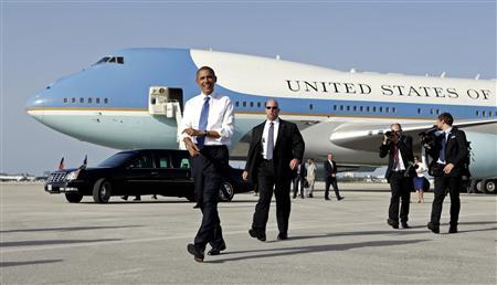 U.S. President Barack Obama rolls up his sleeves while walking from Air Force One upon his arrival in West Palm Beach, Florida July 19, 2012. REUTERS/Kevin Lamarque