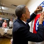 U.S. President Barack Obama autographs a banner while visiting a wounded service member at Walter Reed National Military Medical Center in Bethesda, Maryland, in this June 28, 2012 photograph obtained on July 19, 2012. REUTERS/Pete Souza/Handout