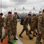 Soldiers pass the Olympic Stadium in the London 2012 Olympic Park in Stratford, east London July 17, 2012. REUTERS/Luke MacGregor