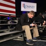 A supporter of Republican presidential candidate and former Massachusetts Governor Mitt Romney checks for news on his phone as he waits for the Romney rally to begin at his South Carolina Primary night rally in Columbia, South Carolina January 21, 2012. REUTERS/Brian Snyder