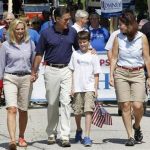 Ann Romney (L-R) holds the hand of her husband, U.S. Republican presidential candidate and former Massachusetts Governor Mitt Romney, as he puts his arm around one of his grandchildren while walking alongside Senator Kelly Ayotte (R-NH) as they take part in the Wolfeboro Fourth of July Parade in Wolfeboro, New Hampshire July 4, 2012. REUTERS/Jessica Rinaldi