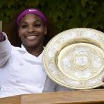 Serena Williams of the U.S. holds her trophy as she stands on the clubhouse balcony after defeating Agnieszka Radwanska of Poland in their women's final tennis match at the Wimbledon tennis championships in London July 7, 2012. REUTERS/Dylan Martinez