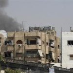 PICTURE TAKEN ON GUIDED GOVERNMENT TOUR Smoke billows near buildings in al-Midan neighbourhood in Damascus July 20, 2012. REUTERS/Stringer